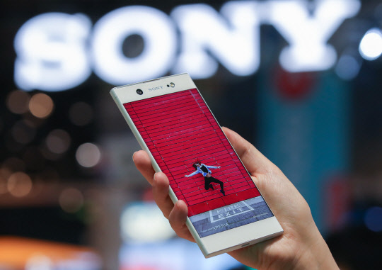 27일(현지시간) 세계 최대 모바일 전시회 '모바일 울드 콩그레스(MWC) 2017'이 열린 스페인 바르셀로나 피라 그란비아 내 소니 부스에서 행사도우미가 엑스페리아 XA1을 들어보이고 있다.      엑스페리아 XA1은 후면에 2300만 화소의 광각 카메라를, 전면에는1600만 화소 카메라를 설치했다. 심플한 디자인을 유지하며 측면 베젤의 두께를 최소한 것이 특징이다.